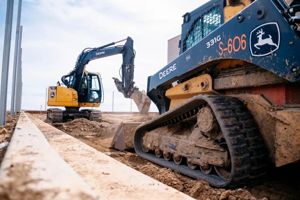 4RE | A John Deere excavator and a skid steer on a job site.